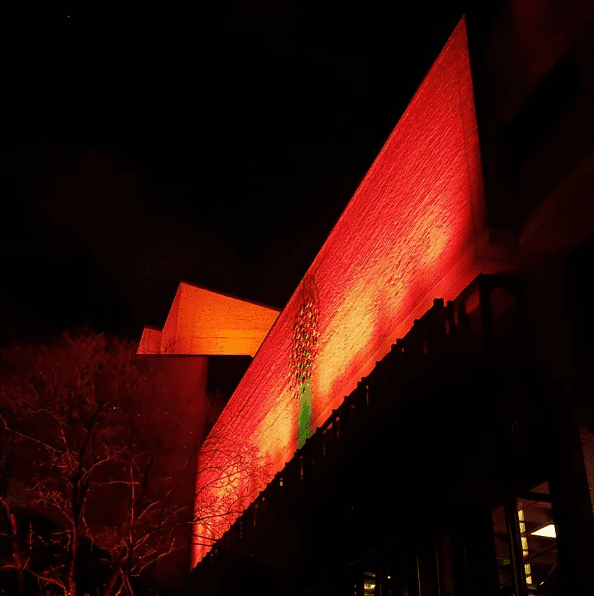 Strahlend rot angeleuchtete Fassade des Gasteig