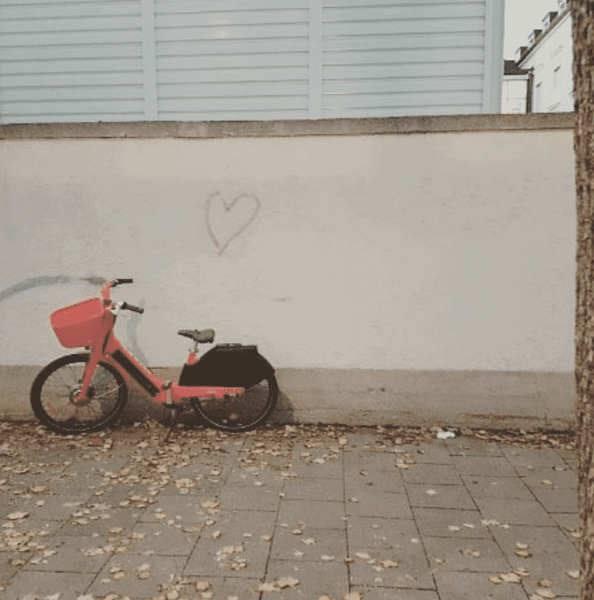 Ein Fahrrad vor einer Wand, auf die ein Herz gemalt ist.