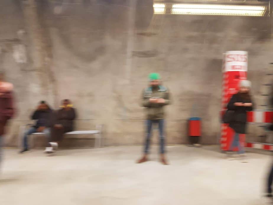 Menschen, die auf die U-Bahn warten, aus der fahrenden U-Bahn fotografiert.