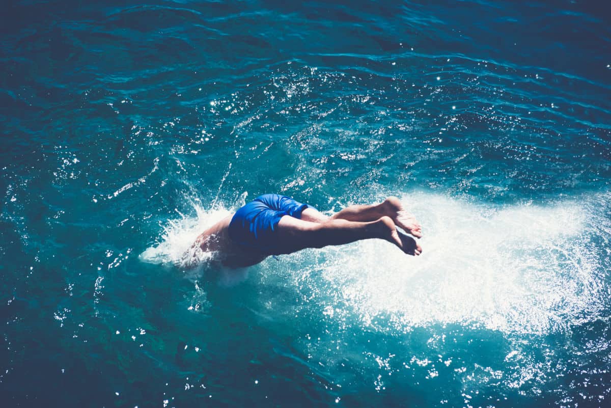 Ein Mann macht einen Kopfsprung ins Wasser.